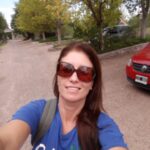 mujer selfie con anteojos de sol y remera azul, arboles de fondo, testimonio cursos online
